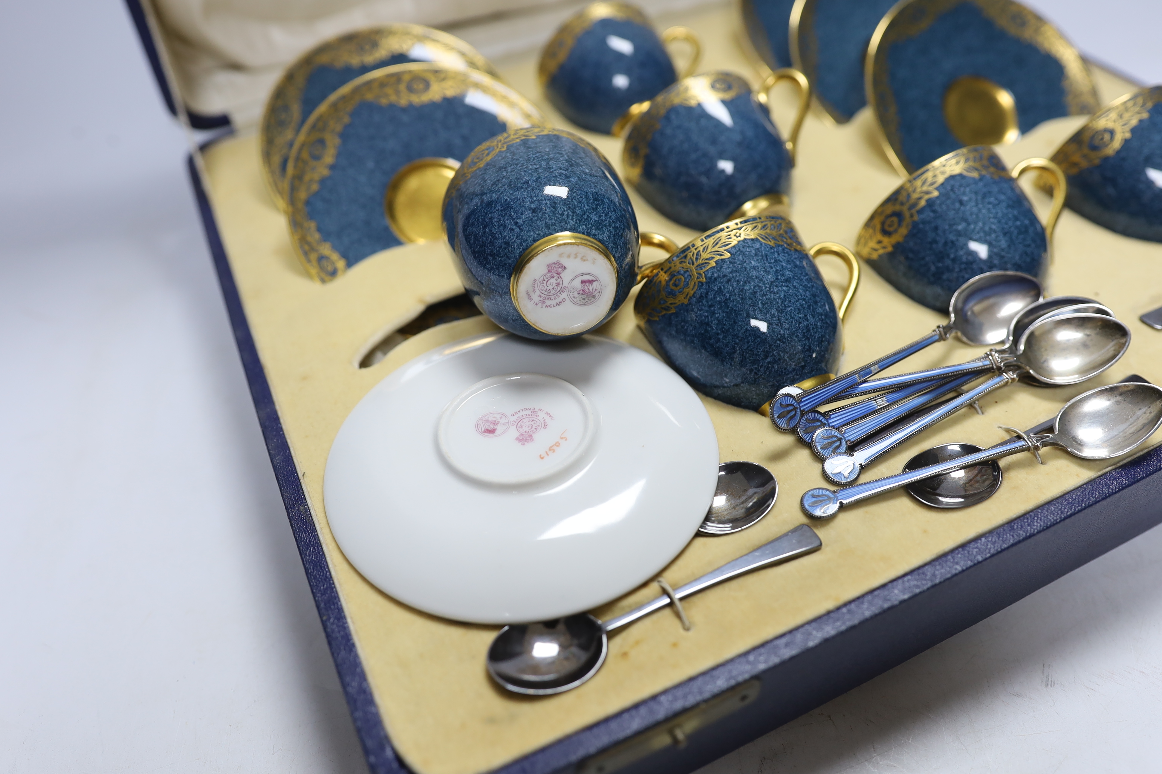 A cased Royal Worcester gilt and powder blue six piece coffee set with silver teaspoons, set of six silver and guilloche enamel teaspoons together with a Meissen blue and white ‘onion pattern’ serving dish, 39cm wide